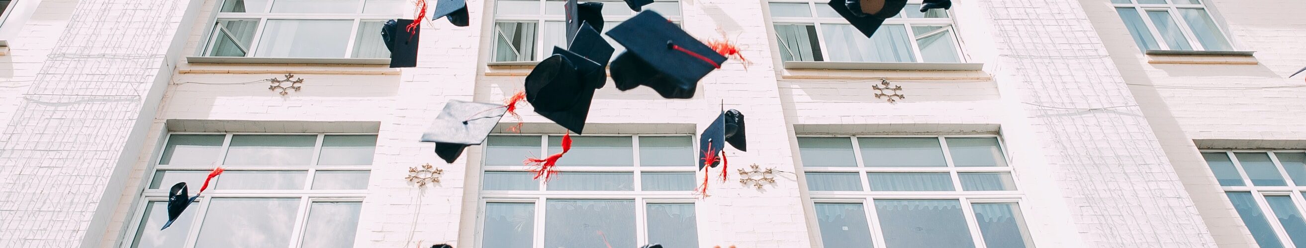 College graduates throwing graduation caps in the air